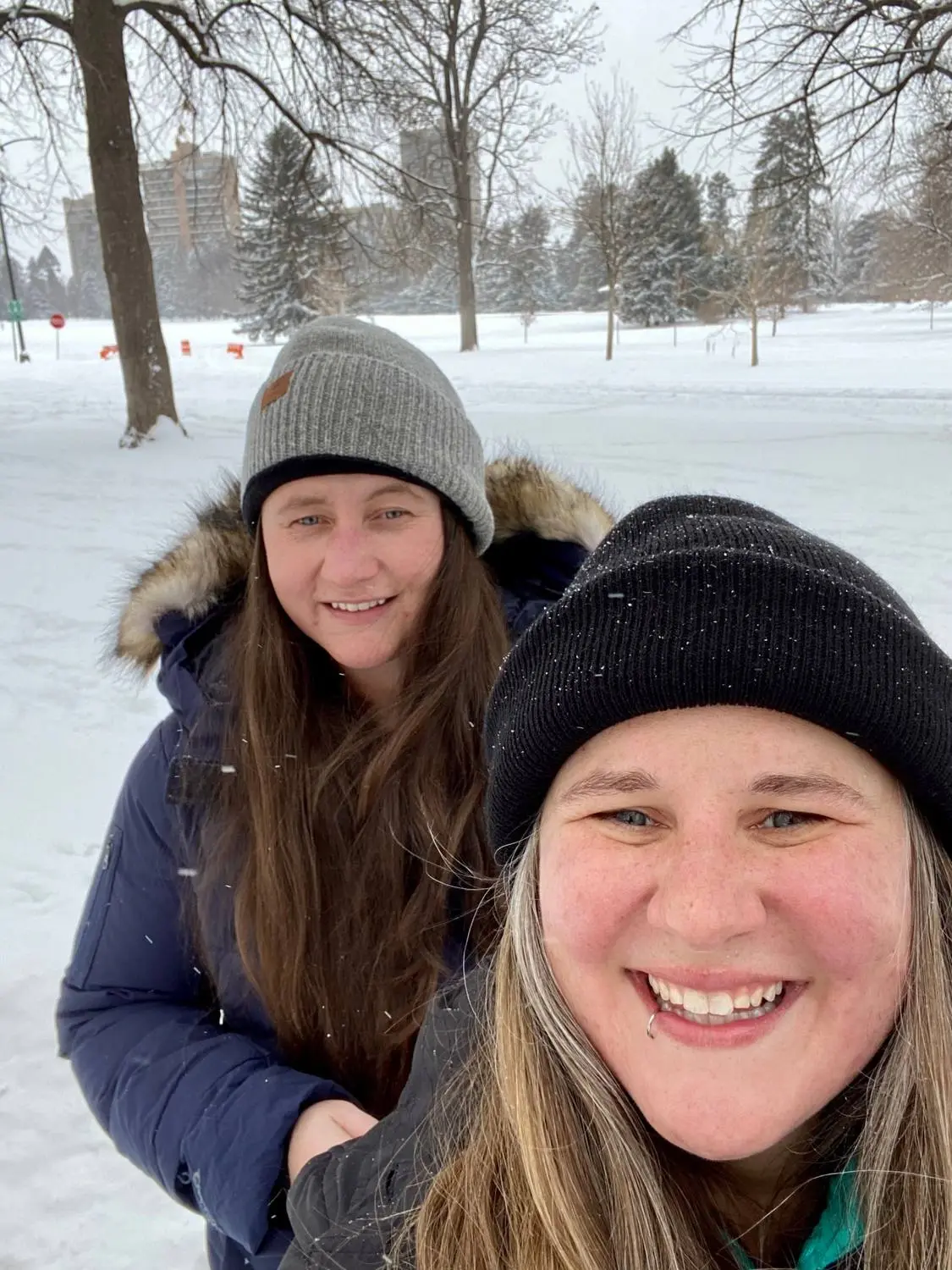 Mariya and Sam in beanies taking a selfie in a snowy park