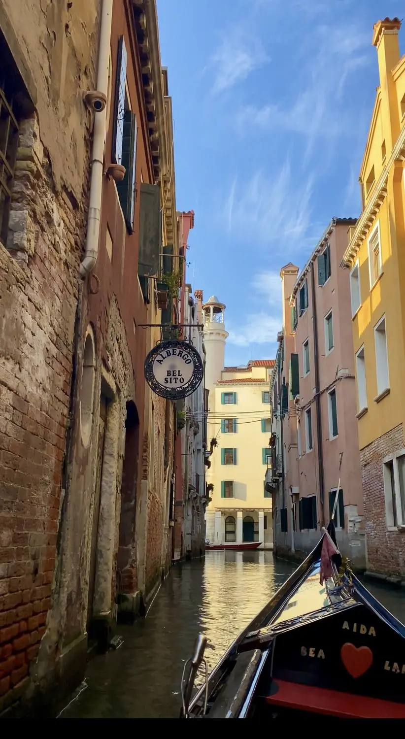 A narrow canal in Venice seen from the bow of a gondola